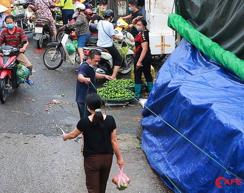 Tại đây, một tiểu thương đeo khẩu trang không đúng cách khi làm việc giữa nơi đông người, vi phạm nghiêm trọng biện pháp phòng chống dịch bệnh Covid-19