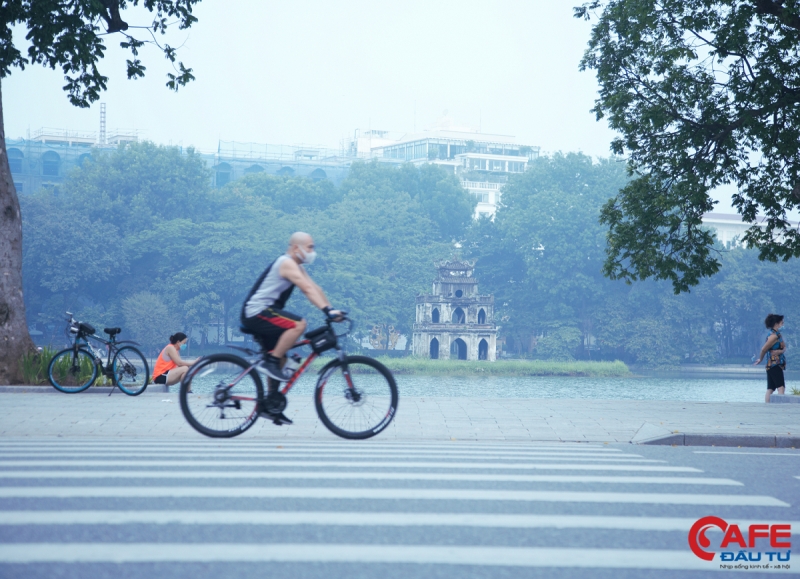 Người dân đạp xe trên tuyến đường Đinh Tiên Hoàng, phía đối diện với tháp rùa