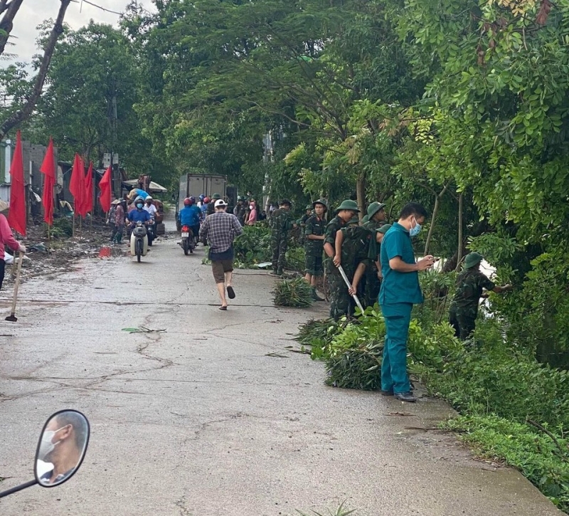 Hình ảnh tổng vệ sinh, tạo quang cảnh khuôn viên cho trường Tiểu học Ngô Thì Nhậm của cán bộ chiến sĩ tiểu đoàn KSQS 103 cùng người dân và các thầy cô giáo