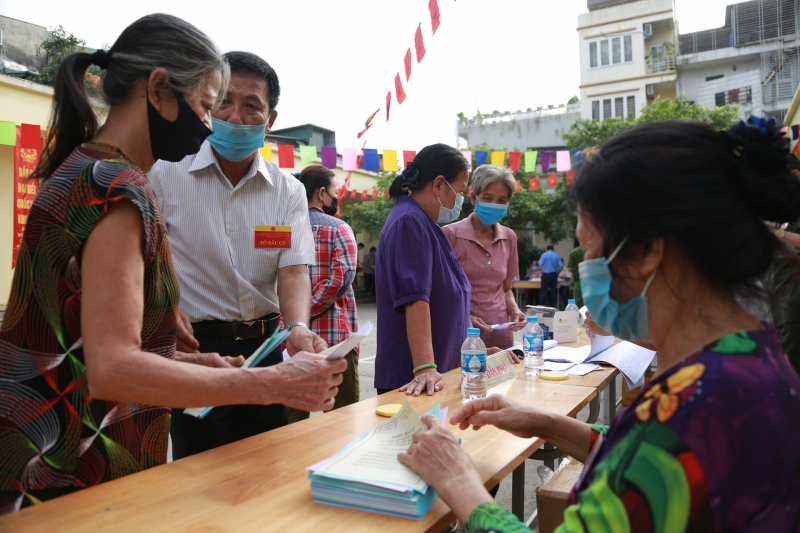 Tại khu vực bên ngoài, lực lượng chức năng, lãnh đạo hỗ trợ các cư tri đến khu vực lấy phiếu bầu