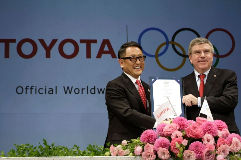 CEO Akio Toyoda của Toyota (trái) và Chủ tịch IOC Thomas Bach trong lễ ký thoả thuận vào năm 2015 đưa Toyota trở thành một nhà tài trợ toàn cầu của Thế vận hội (Ảnh: Wall Street Journal)