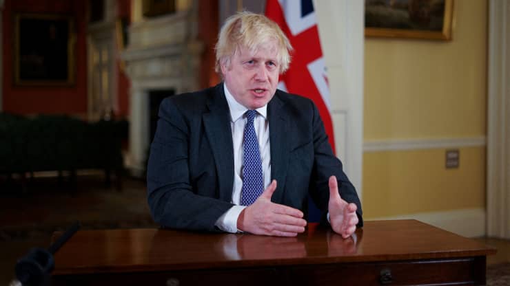 Thủ tướng Anh Boris Johnson ra hiệu khi ghi địa chỉ trước quốc gia để cung cấp thông tin cập nhật về chương trình vắc xin tăng cường COVID-19 tại Phố Downing, London, Anh vào ngày 12/12/2021 (Ảnh: CNBC)